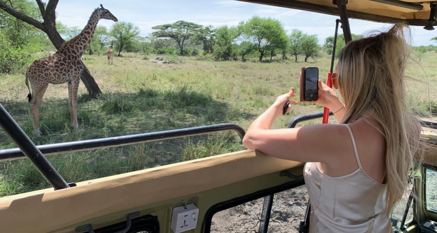 A game drive vehicle among wildlife in Queen Elizabeth National Park